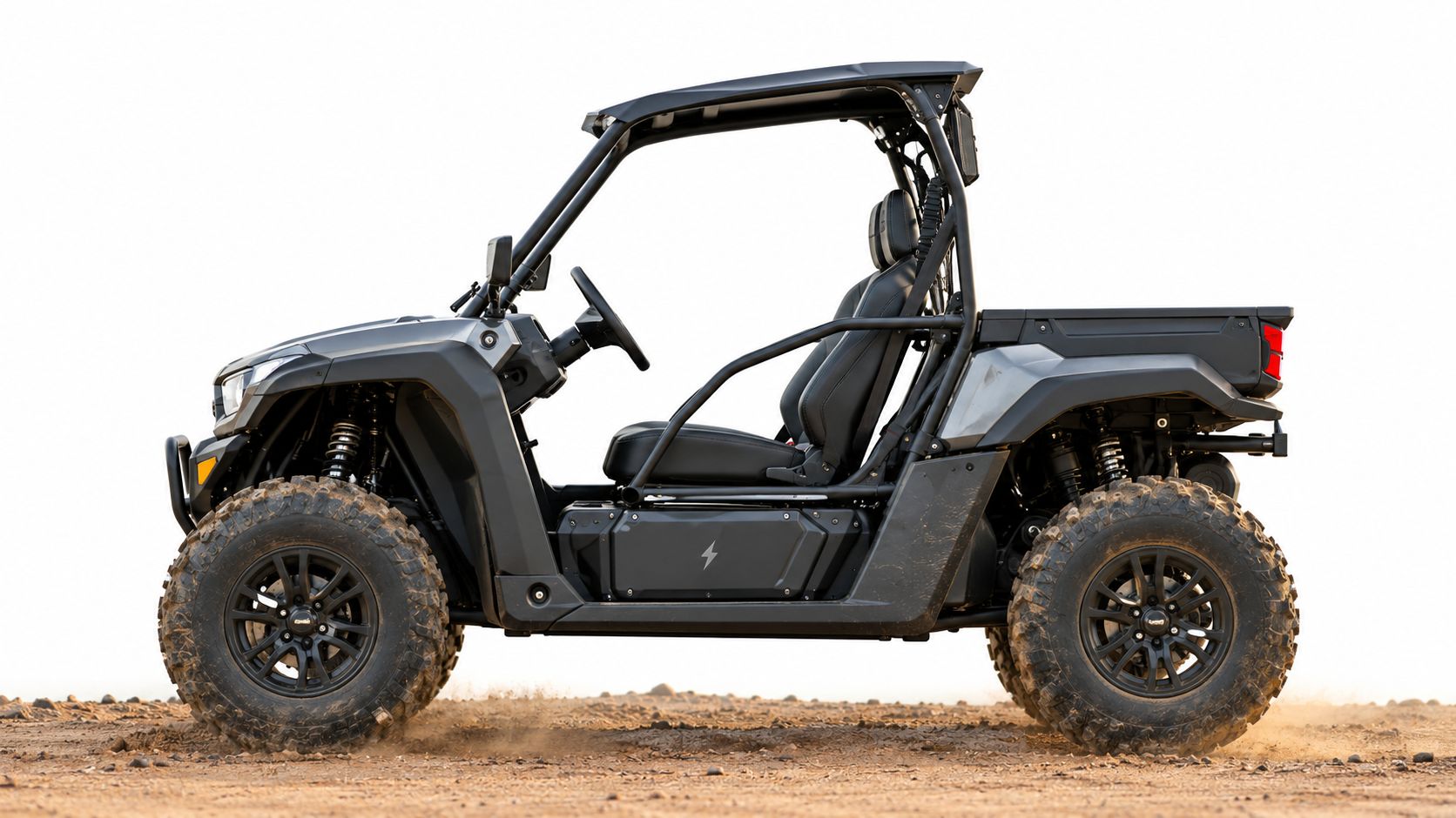 A sleek dark gray electric utility vehicle driving across a dusty off-road terrain against a bright background.